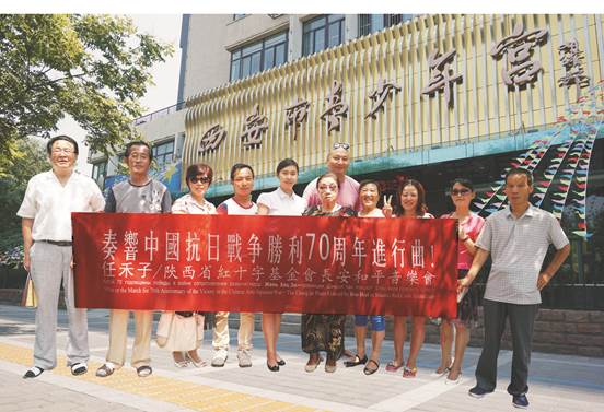 图1、任禾子／陕西省红十字基金会长安和平音乐会“奏响中国抗日战争胜利70周年交响曲”感人欣悦。左五为音乐舞蹈师任禾子硕士。   张百庆  摄