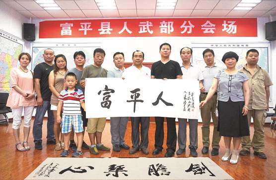 图10、抗日出征红土地，剑胆琴心富平人。刘吉墩（右六）在八路军抗日誓师出征地历史文化采风行中为习近平主席家乡的军民题字赠作。    张百庆  摄