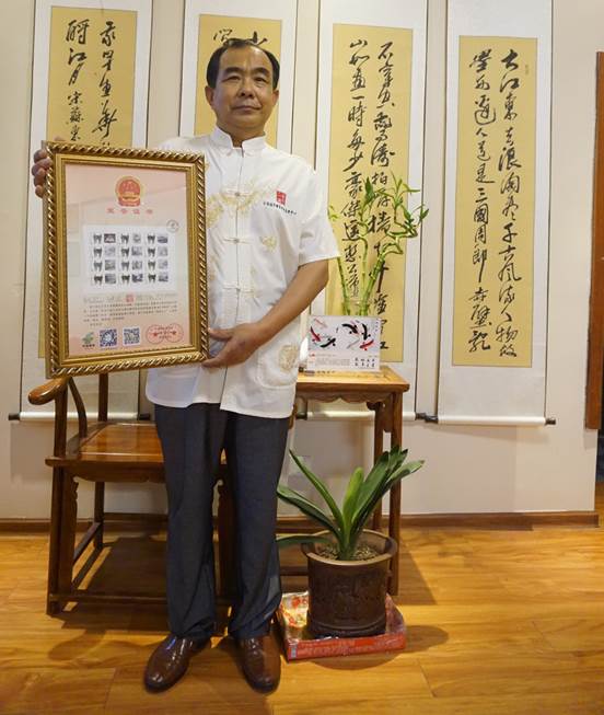 图13、刘吉墩大师的新精品中选入编《中国纪念抗日战争胜利暨世界反法西斯战争70周年邮品纪念册》限量珍藏版，并获授“中国当代书画名家”新称号。    张百庆  摄