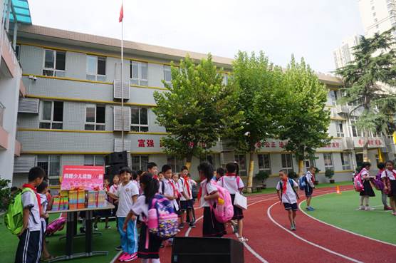 图16、留着同唱“抗日战争胜利歌”的快乐欣赏少儿读物的西安市金光门小学的同学们。   张百庆  摄